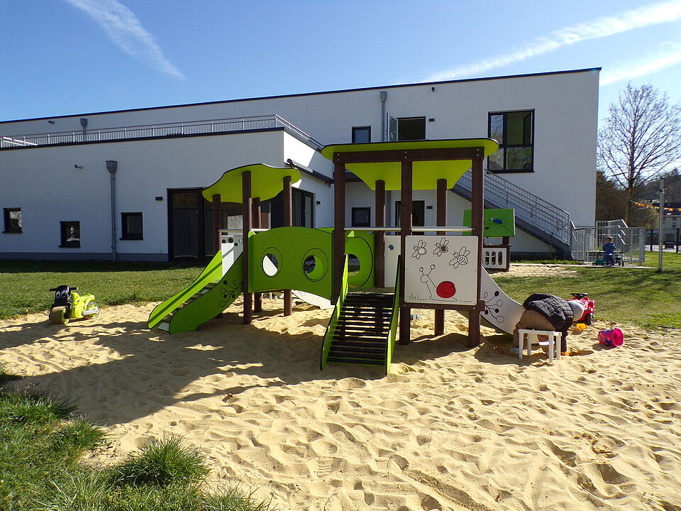 Außengelände der Peppaburg mit Spielburg im Sandkasten