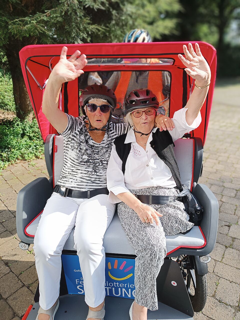 Zwei ältere Damen sitzen in der Rikscha und machen eine Fahrt durch Olpe