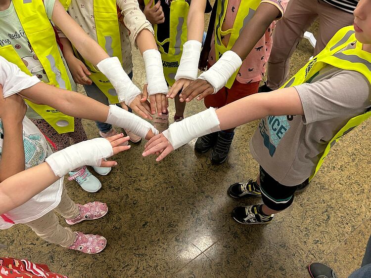Kinder halten ihren Arm mit Verband in die Mitte