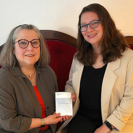 K. Blumentrath, eine angehende Rentnerin und K. Schüren, Beraterin für Antidiskriminierung sitzen auf dem roten Sofa im DRK-Mehrgenerationenhaus in Olpe