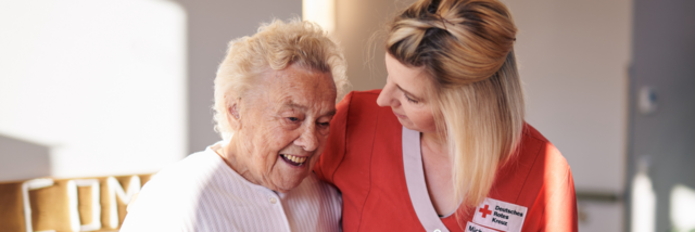 Eine Pflegekraft kümmert sich um eine demenzkranke Frau.